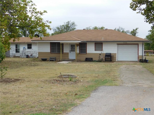 ranch-style house featuring a front yard and a garage