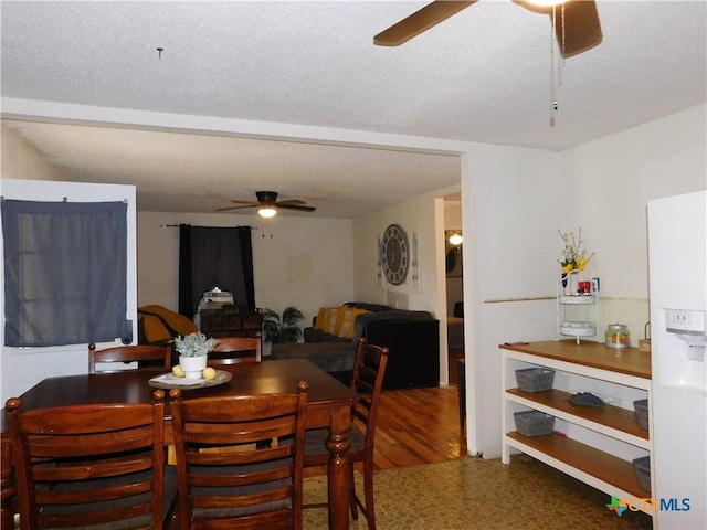 dining area featuring ceiling fan and a textured ceiling