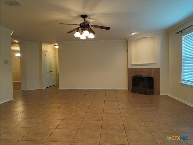 unfurnished living room featuring ceiling fan, a fireplace, light tile patterned floors, and crown molding