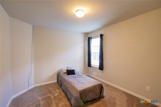 carpeted bedroom featuring a textured ceiling