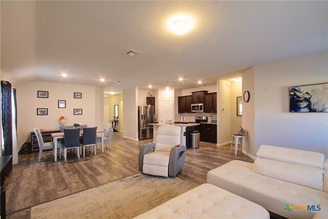 living room featuring hardwood / wood-style flooring and vaulted ceiling