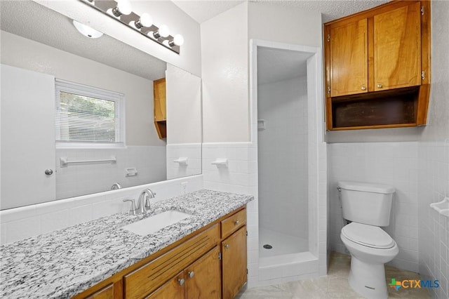 906 Laurie Ln, Copperas Cove, TX 76522 - full bath featuring tile walls, vanity, a stall shower, a wainscoted wall, and a textured ceiling