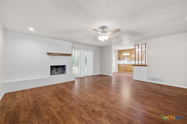 906 Laurie Ln, Copperas Cove, TX 76522 - unfurnished living room featuring a textured ceiling, a ceiling fan, wood finished floors, and a brick fireplace