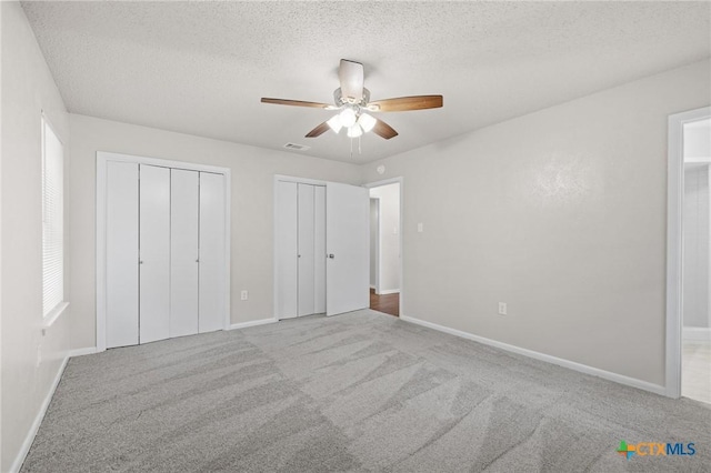 906 Laurie Ln, Copperas Cove, TX 76522 - unfurnished bedroom featuring two closets, carpet floors, a textured ceiling, and ceiling fan