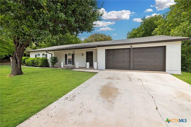 906 Laurie Ln, Copperas Cove, TX 76522 - ranch-style house with a porch, an attached garage, a front lawn, driveway, and brick siding