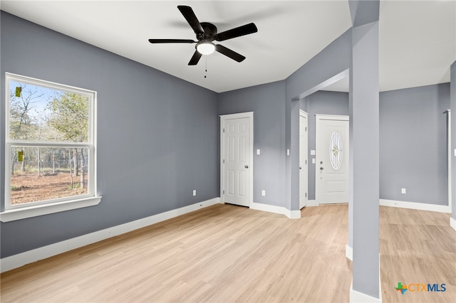 unfurnished bedroom with ceiling fan, light hardwood / wood-style flooring, and two closets