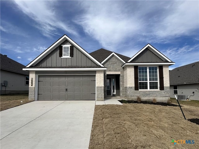 craftsman inspired home with board and batten siding, concrete driveway, brick siding, and central air condition unit