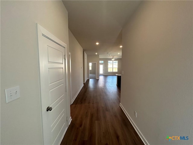 hallway with baseboards, dark wood-type flooring, and recessed lighting