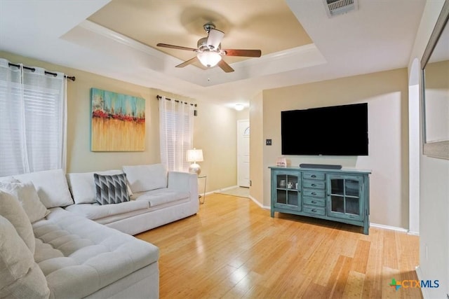 216 Pullman Place Blvd, Temple, TX 76502 - living room featuring a raised ceiling, light wood finished floors, a ceiling fan, and baseboards