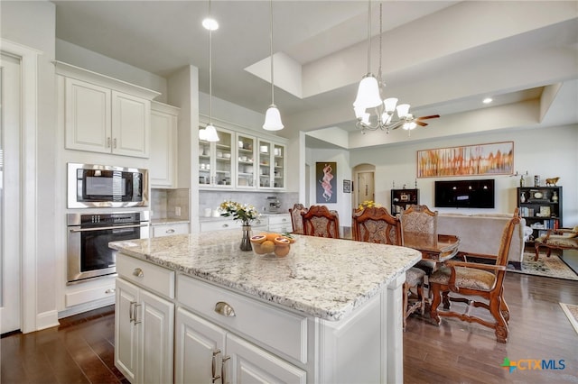 1812 Gibraltar Dr, San Marcos, TX 78666 - kitchen featuring appliances with stainless steel finishes, a chandelier, dark wood-style flooring, arched walkways, and open floor plan
