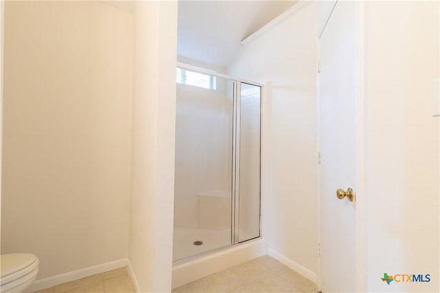 bathroom with toilet, lofted ceiling, tile patterned floors, and a shower with shower door