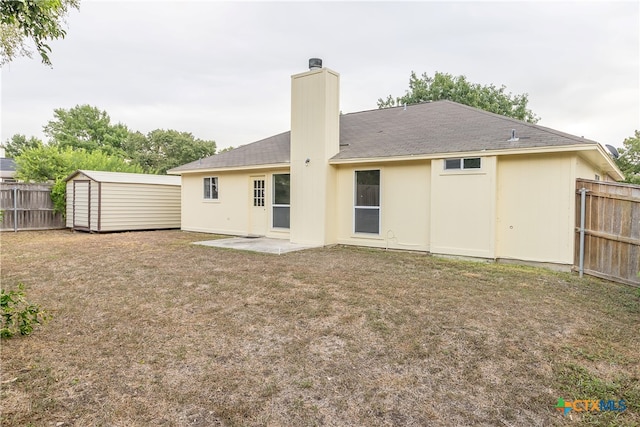 back of house featuring a shed, a yard, and a patio area