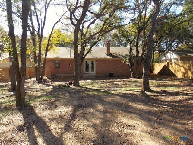 765 Benchmark Trl, Belton, TX 76513 - rear view of house featuring french doors, fence, brick siding, and a chimney