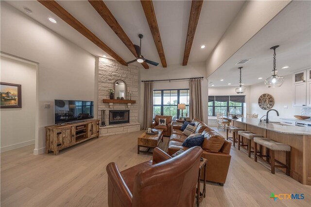 150 Panorama Dr, Wimberley, TX 78676 - living room with light wood-type flooring, a stone fireplace, ceiling fan, beam ceiling, and recessed lighting