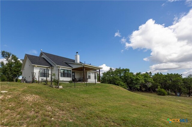 150 Panorama Dr, Wimberley, TX 78676 - rear view of house featuring a yard, a chimney, and board and batten siding