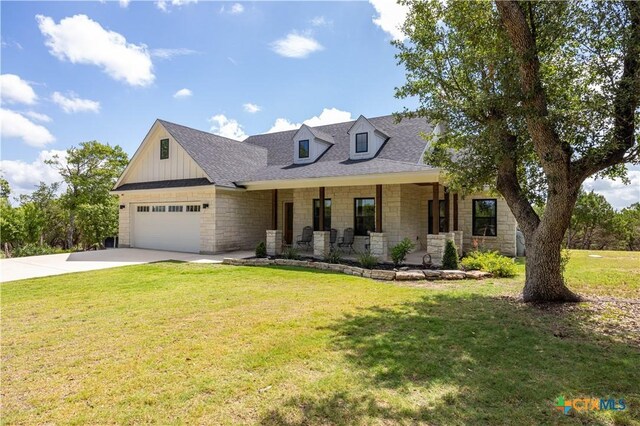 150 Panorama Dr, Wimberley, TX 78676 - view of front of property featuring stone siding, a porch, driveway, a garage, and a front lawn
