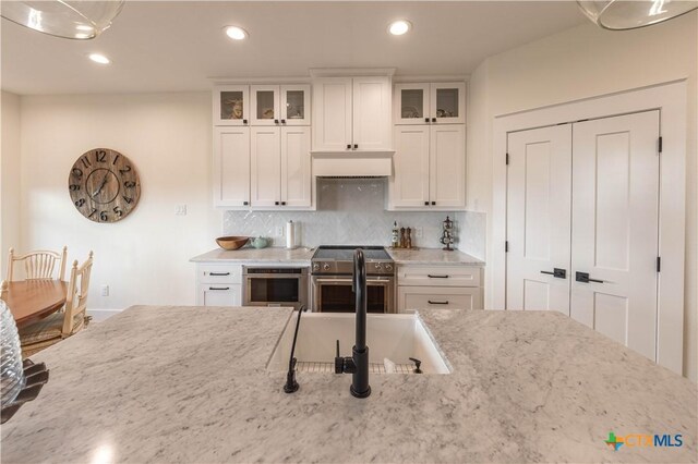 150 Panorama Dr, Wimberley, TX 78676 - kitchen featuring stainless steel appliances, light stone counters, backsplash, white cabinetry, and recessed lighting