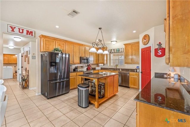 846 Thomas St, Copperas Cove, TX 76522 - kitchen featuring appliances with stainless steel finishes, washer / dryer, light tile patterned floors, dark stone countertops, and recessed lighting