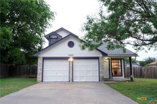 view of front facade with driveway, an attached garage, fence, and a front yard