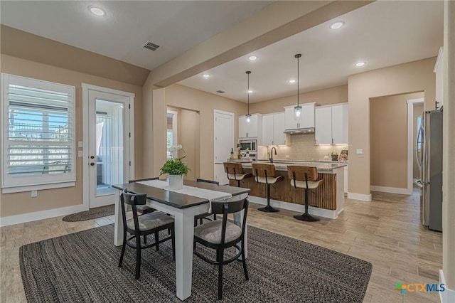 dining area with sink and light wood-type flooring