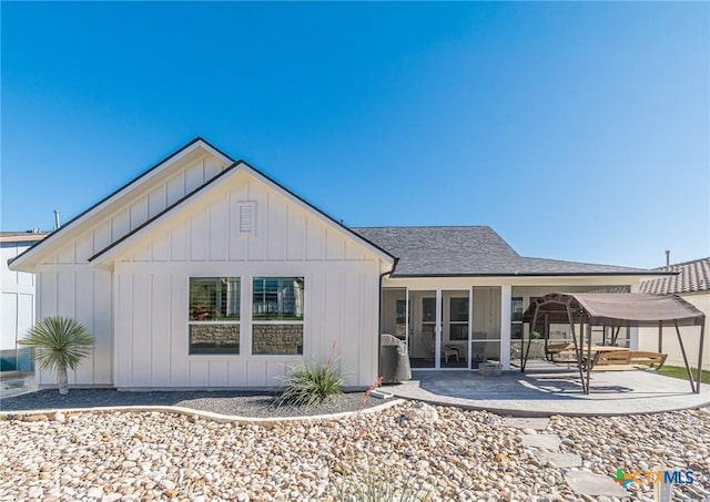 back of property with a patio area and a sunroom