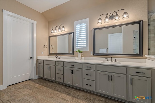 bathroom featuring vanity, wood-type flooring, and vaulted ceiling