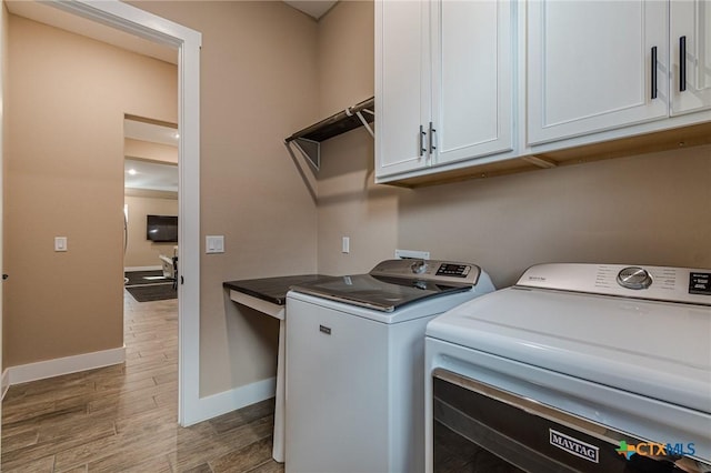 washroom featuring cabinets and washing machine and dryer