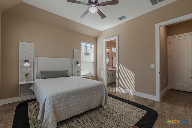 bedroom featuring ceiling fan, lofted ceiling, dark wood-type flooring, and ensuite bath