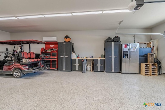 garage with stainless steel fridge and a garage door opener