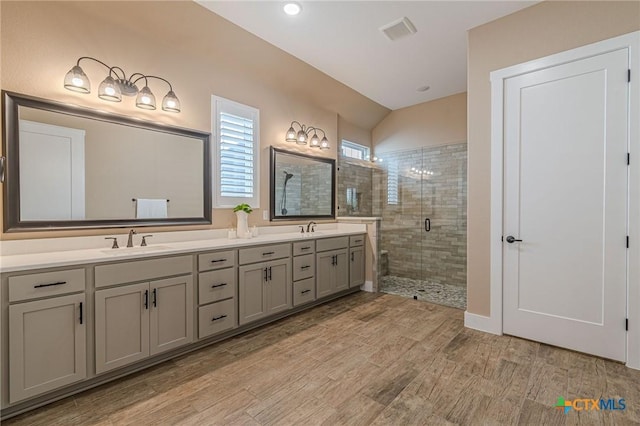 bathroom with lofted ceiling, vanity, and an enclosed shower