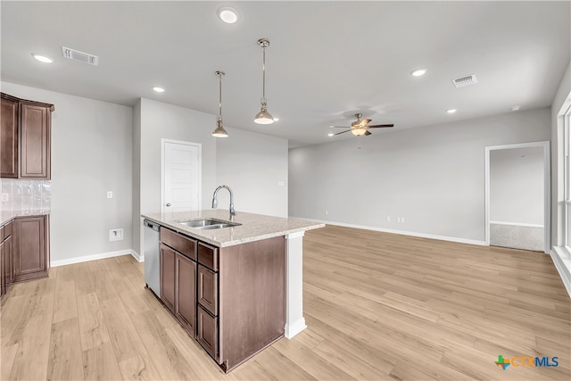 kitchen with sink, light stone counters, dishwasher, and light hardwood / wood-style flooring