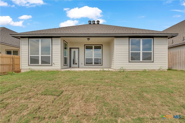 rear view of property with a lawn