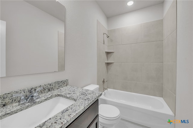 full bathroom with vanity, tiled shower / bath, and toilet