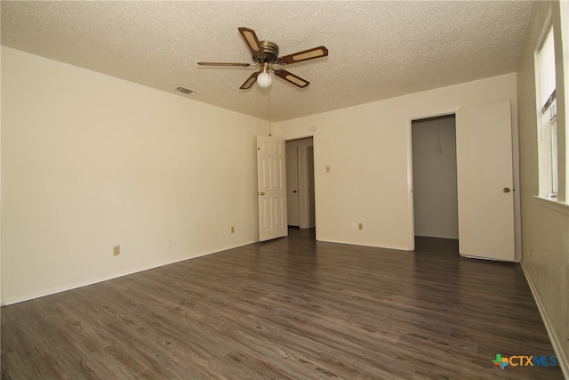 unfurnished room featuring ceiling fan, dark hardwood / wood-style flooring, and a textured ceiling