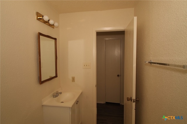 bathroom featuring a textured ceiling, vanity, and wood-type flooring