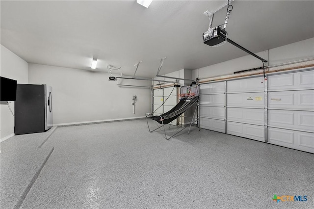 garage featuring a garage door opener and stainless steel fridge with ice dispenser