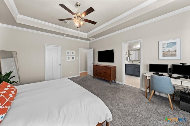 carpeted bedroom with ceiling fan, ensuite bathroom, a tray ceiling, and crown molding