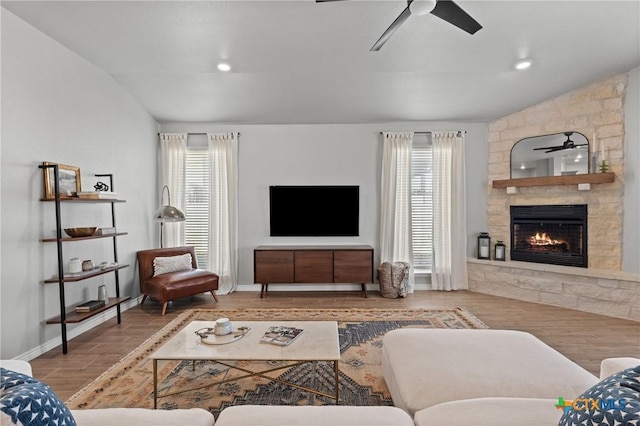 living room with ceiling fan, plenty of natural light, and a fireplace