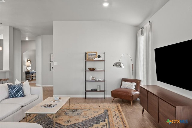 living room with light wood-type flooring and vaulted ceiling