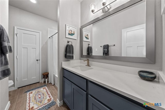 bathroom with toilet, a shower with shower curtain, and vanity