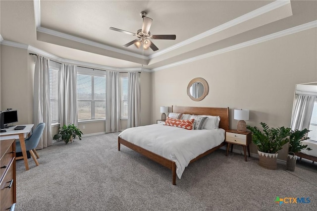 carpeted bedroom featuring ceiling fan, ornamental molding, and a tray ceiling