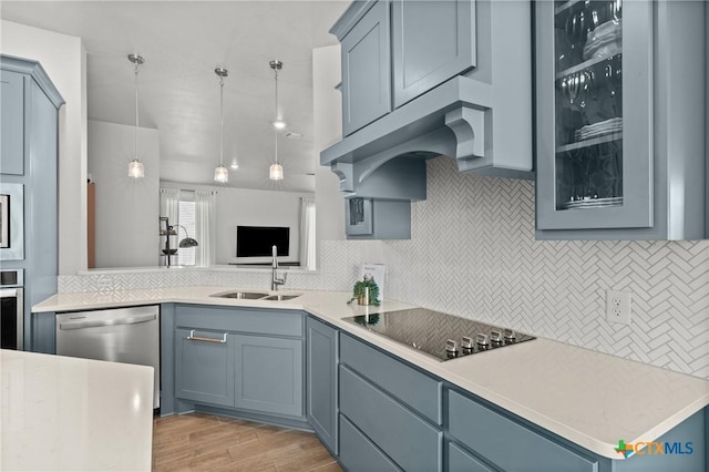 kitchen featuring kitchen peninsula, decorative light fixtures, sink, tasteful backsplash, and stainless steel appliances