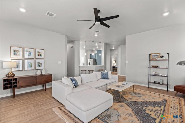 living room featuring ceiling fan and light hardwood / wood-style flooring