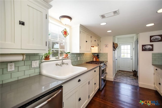 24135 State Highway 172, Port Lavaca, TX 77979 - kitchen featuring stainless steel appliances, dark wood-style flooring, white cabinetry, tasteful backsplash, and recessed lighting
