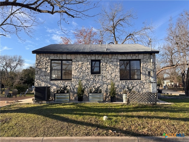 view of front facade featuring a front lawn and cooling unit