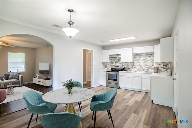 1504 Phyllis Dr, Copperas Cove, TX 76522 - kitchen with stainless steel electric range, arched walkways, backsplash, a sink, and white cabinets