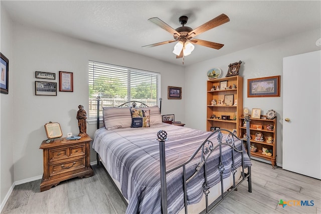 bedroom with a textured ceiling, light hardwood / wood-style floors, and ceiling fan