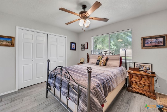 bedroom with ceiling fan, a textured ceiling, a closet, and light wood-type flooring