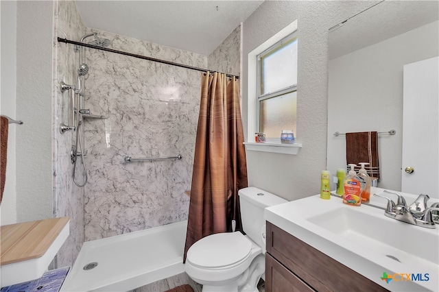 bathroom with curtained shower, vanity, a textured ceiling, and toilet