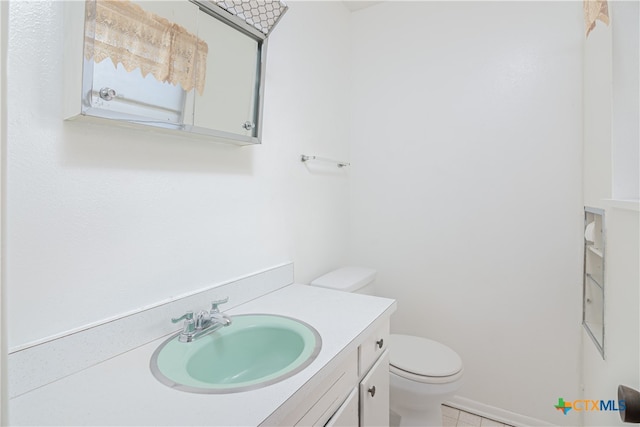 bathroom featuring tile patterned flooring, vanity, and toilet